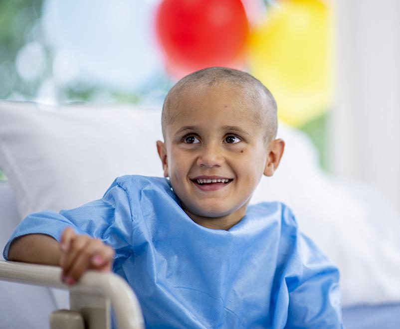 患癌症的男孩在病床上微笑