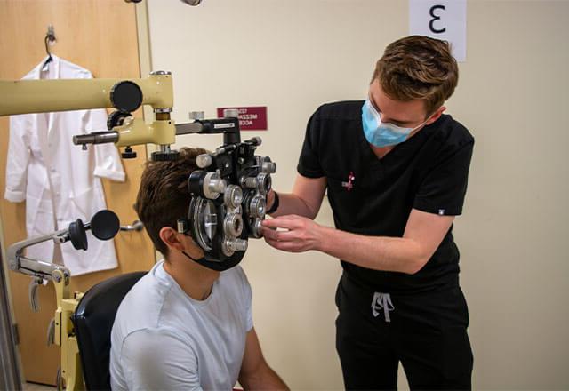 Bryce Patrick St. Clair conducts an eye exam for a patient at CASA.